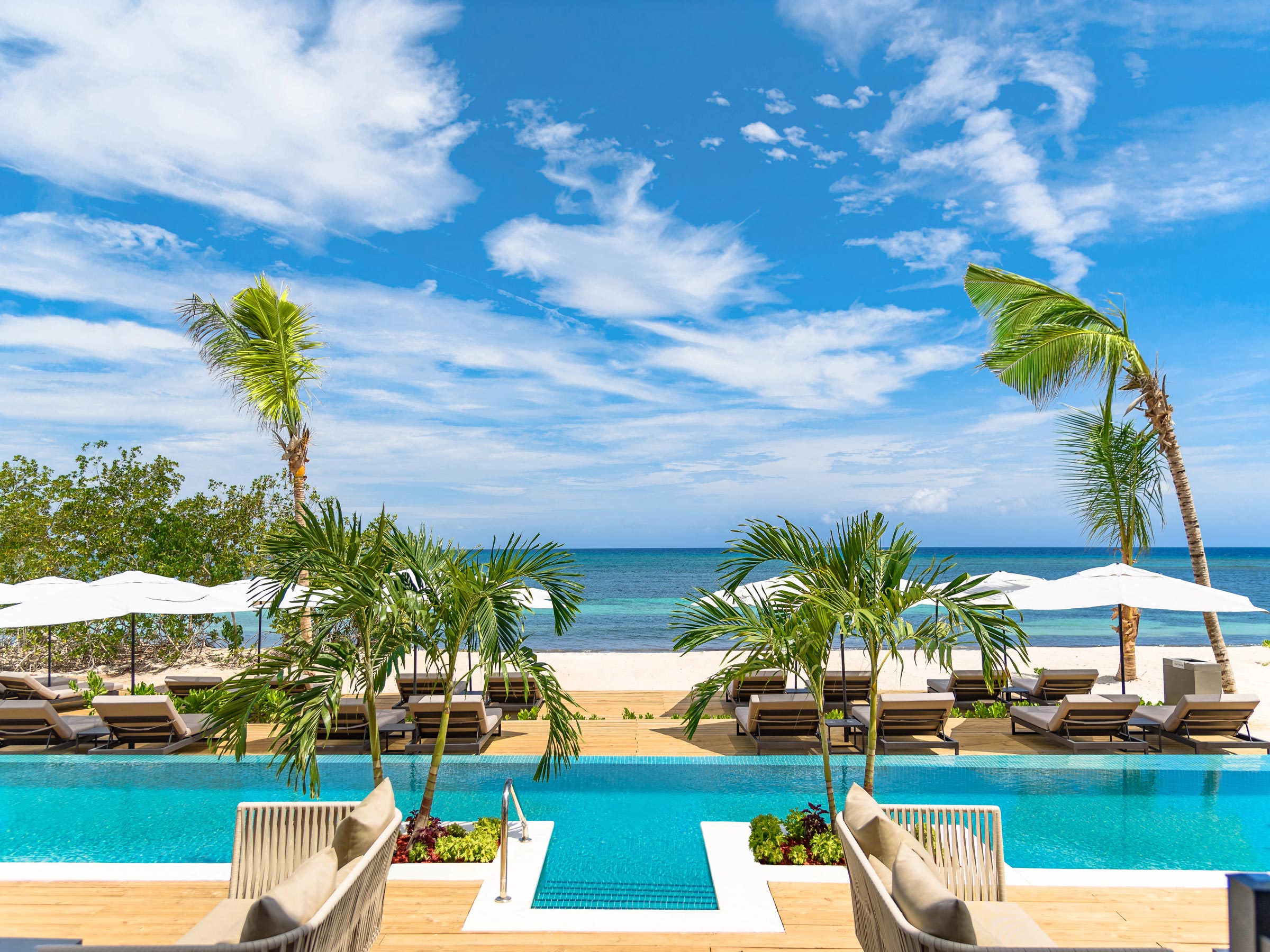 Détendez-vous au bord de la piscine Excellence Club et profitez de la vue sur la plage lorsque vous séjournez dans la suite Excellence Club Suite villa bord de plage avec bassin de plongeon